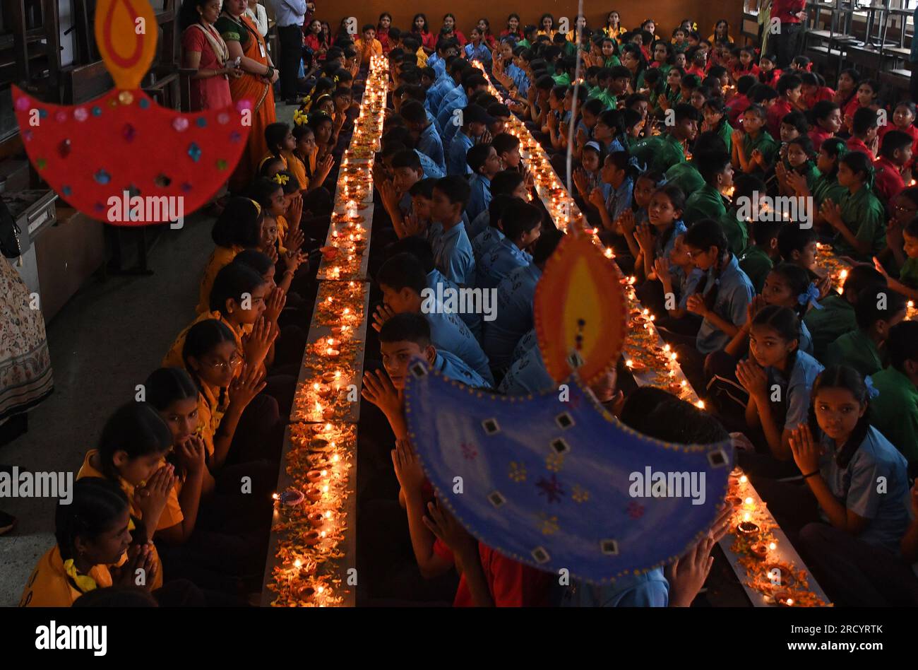 Mumbai, Indien. 17. Juli 2023. Schüler von Shivaji Shikshan Sanstha sitzen in einer Schlange, zünden eine Diya (Erdlattnampe) an und beten anlässlich Ashadha Amavasya in Mumbai mit gefalteten Händen. Deep (Beleuchtung Erdlampen) Pooja wurde mit Lampen unterschiedlicher Größe und Metallen durchgeführt, die alle zusammen beleuchtet wurden. Die Schüler saßen vor den Tieflampen (Erdlampen) und sangen Slokas (sanskrit zitiert), während sie sich auf die Flamme der Erdlampen konzentrierten, die helfen, die Konzentration zu verbessern und positive Vibes, Licht und Energie zu bringen. Kredit: SOPA Images Limited/Alamy Live News Stockfoto