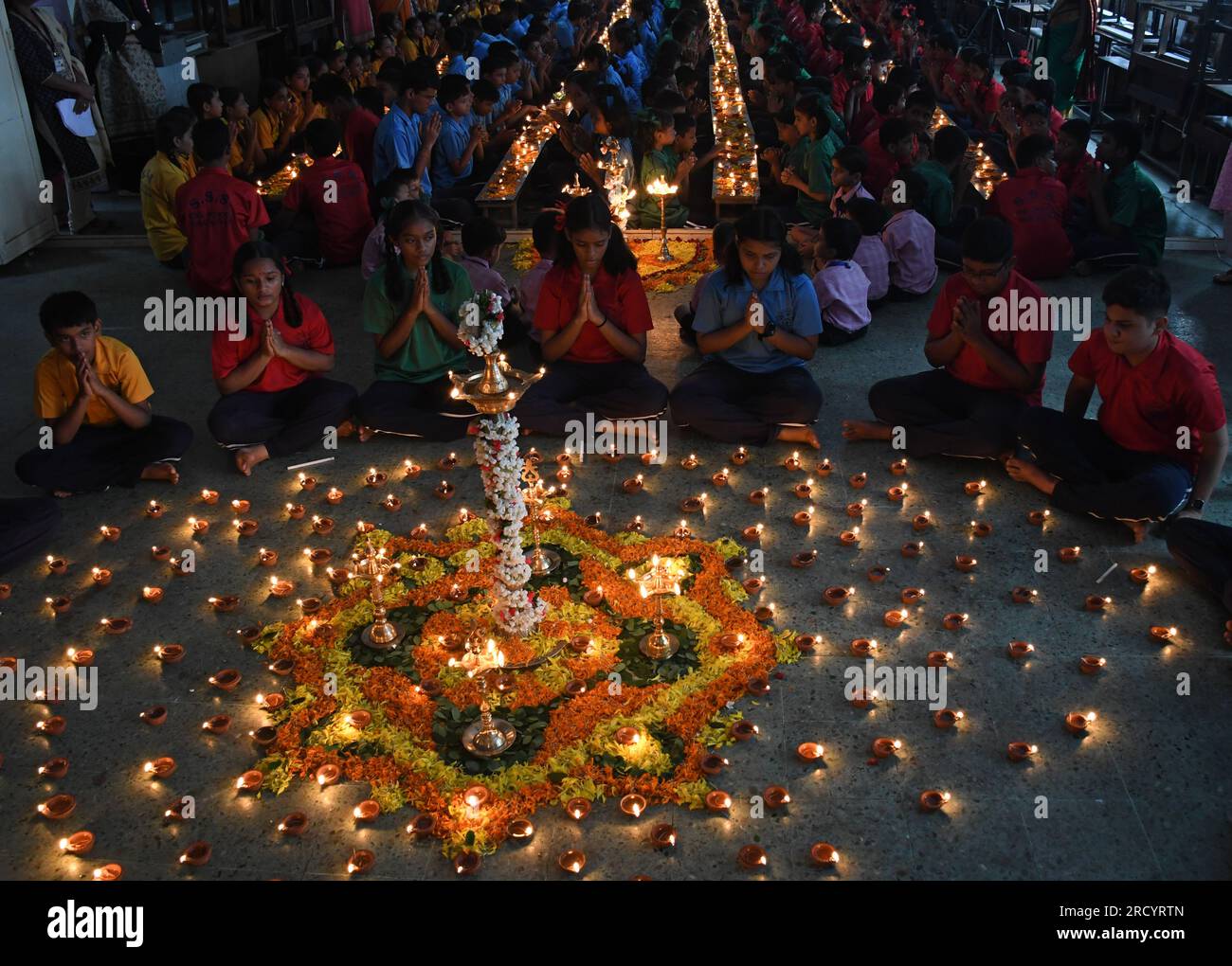 Mumbai, Indien. 17. Juli 2023. Schüler von Shivaji Shikshan Sanstha sitzen im Kreis, zünden eine Diya (Erdlattröhre) an und beten anlässlich Ashadha Amavasya in Mumbai mit gefalteten Händen. Deep (Beleuchtung Erdlampen) Pooja wurde mit Lampen unterschiedlicher Größe und Metallen durchgeführt, die alle zusammen beleuchtet wurden. Die Schüler saßen vor den Tieflampen (Erdlampen) und sangen Slokas (sanskrit zitiert), während sie sich auf die Flamme der Erdlampen konzentrierten, die helfen, die Konzentration zu verbessern und positive Vibes, Licht und Energie zu bringen. Kredit: SOPA Images Limited/Alamy Live News Stockfoto