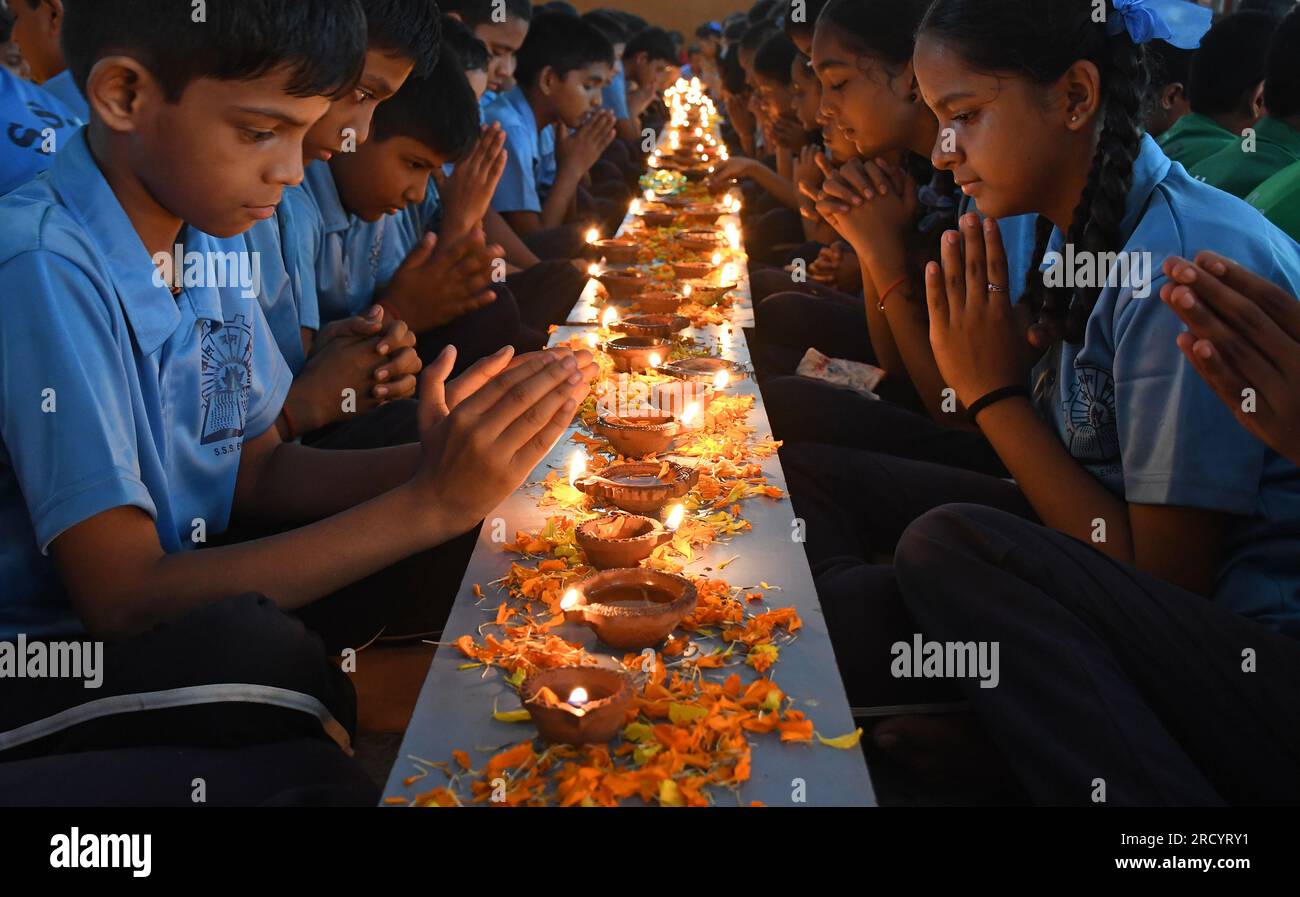 Mumbai, Indien. 17. Juli 2023. Schüler von Shivaji Shikshan Sanstha sitzen in einer Schlange, zünden eine Diya (Erdlattnampe) an und beten anlässlich Ashadha Amavasya in Mumbai mit gefalteten Händen. Deep (Beleuchtung Erdlampen) Pooja wurde mit Lampen unterschiedlicher Größe und Metallen durchgeführt, die alle zusammen beleuchtet wurden. Die Schüler saßen vor den Tieflampen (Erdlampen) und sangen Slokas (sanskrit zitiert), während sie sich auf die Flamme der Erdlampen konzentrierten, die helfen, die Konzentration zu verbessern und positive Vibes, Licht und Energie zu bringen. Kredit: SOPA Images Limited/Alamy Live News Stockfoto