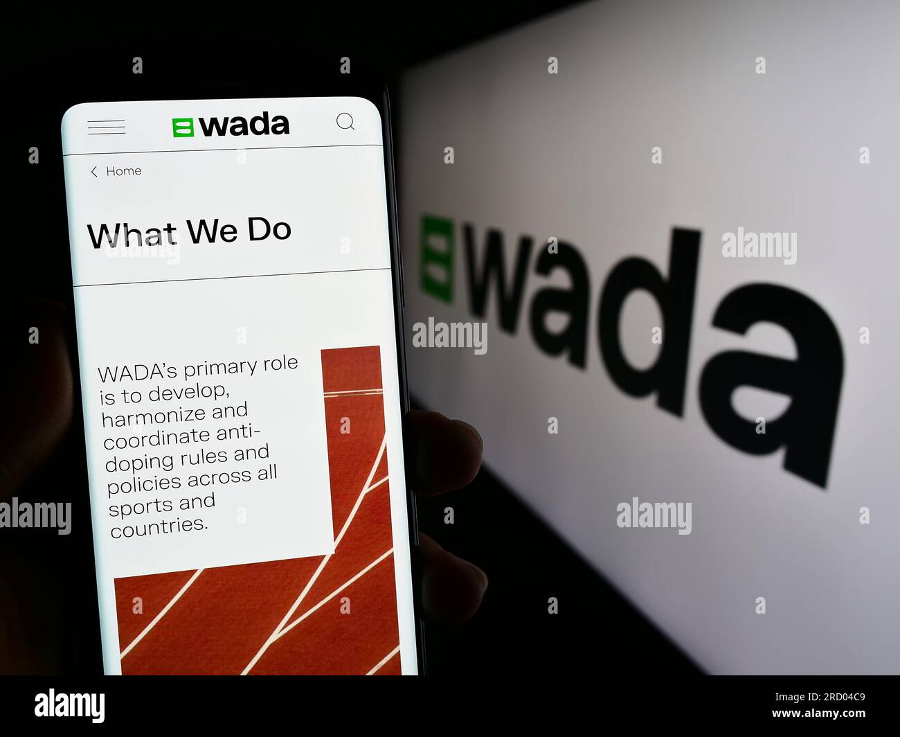 Person, die ein Mobiltelefon mit einer Webseite der Organisation World Anti-Doping Agency (WADA) auf dem Bildschirm mit Logo hält. Konzentrieren Sie sich auf die Mitte des Telefondisplays. Stockfoto