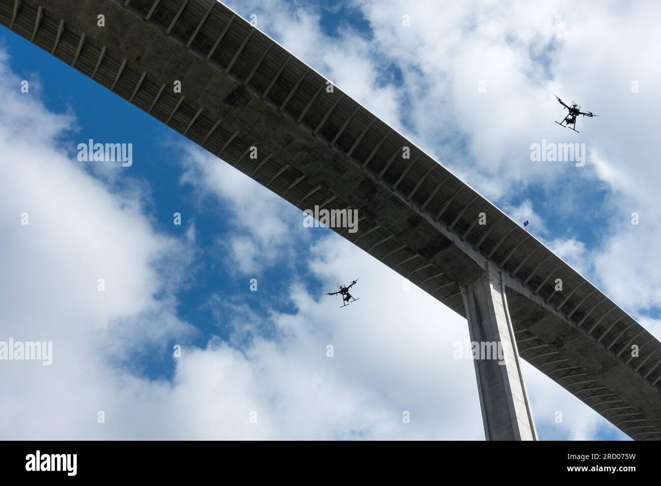 Drohnen fliegen über die Brücke. Drohnenangriff, Drohnenverkehrskontrolle, Polizei, Militärdrohne... Konzept Stockfoto