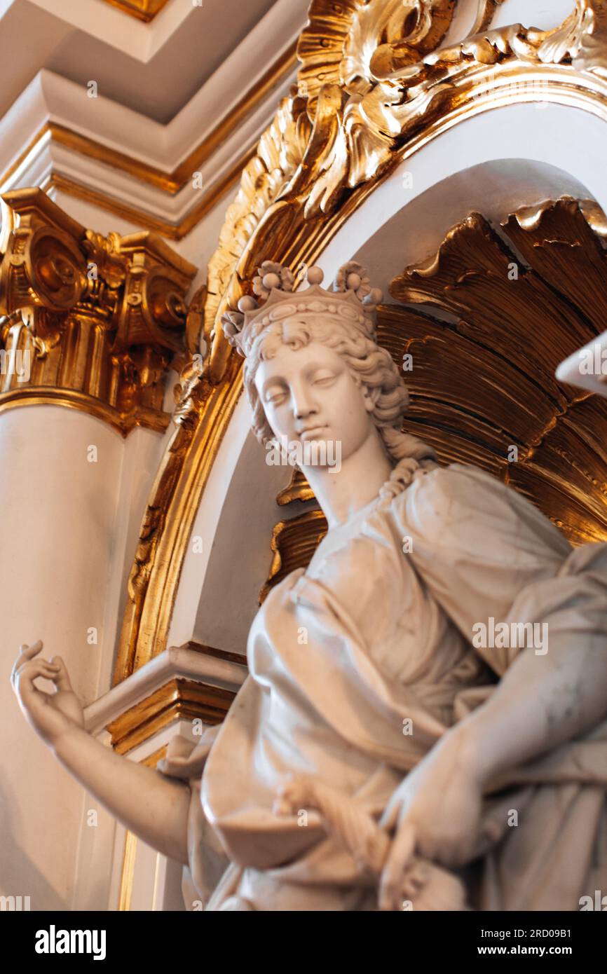 Klassische antike Marmorskulptur einer Frau mit goldenen Ornamenten im Staatlichen Eremitage-Museum in St. Petersburg, Russland. Beige minimalistische Innenausstattung Stockfoto