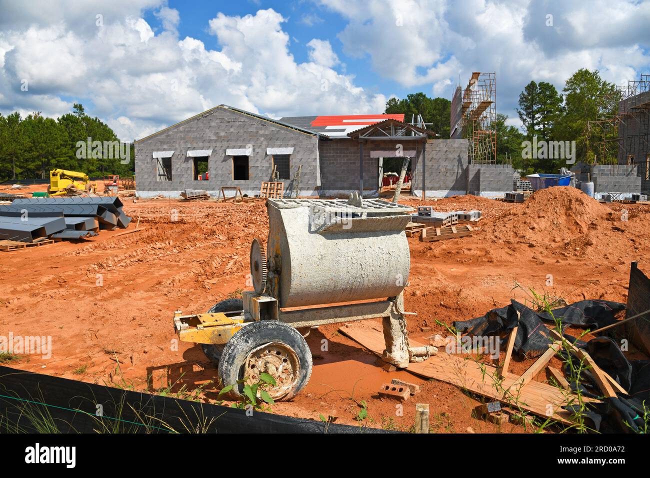 Zementmischer auf einer Baustelle für ein neues Gewerbegebäude mit Schwerpunkt auf Mischer. Stockfoto