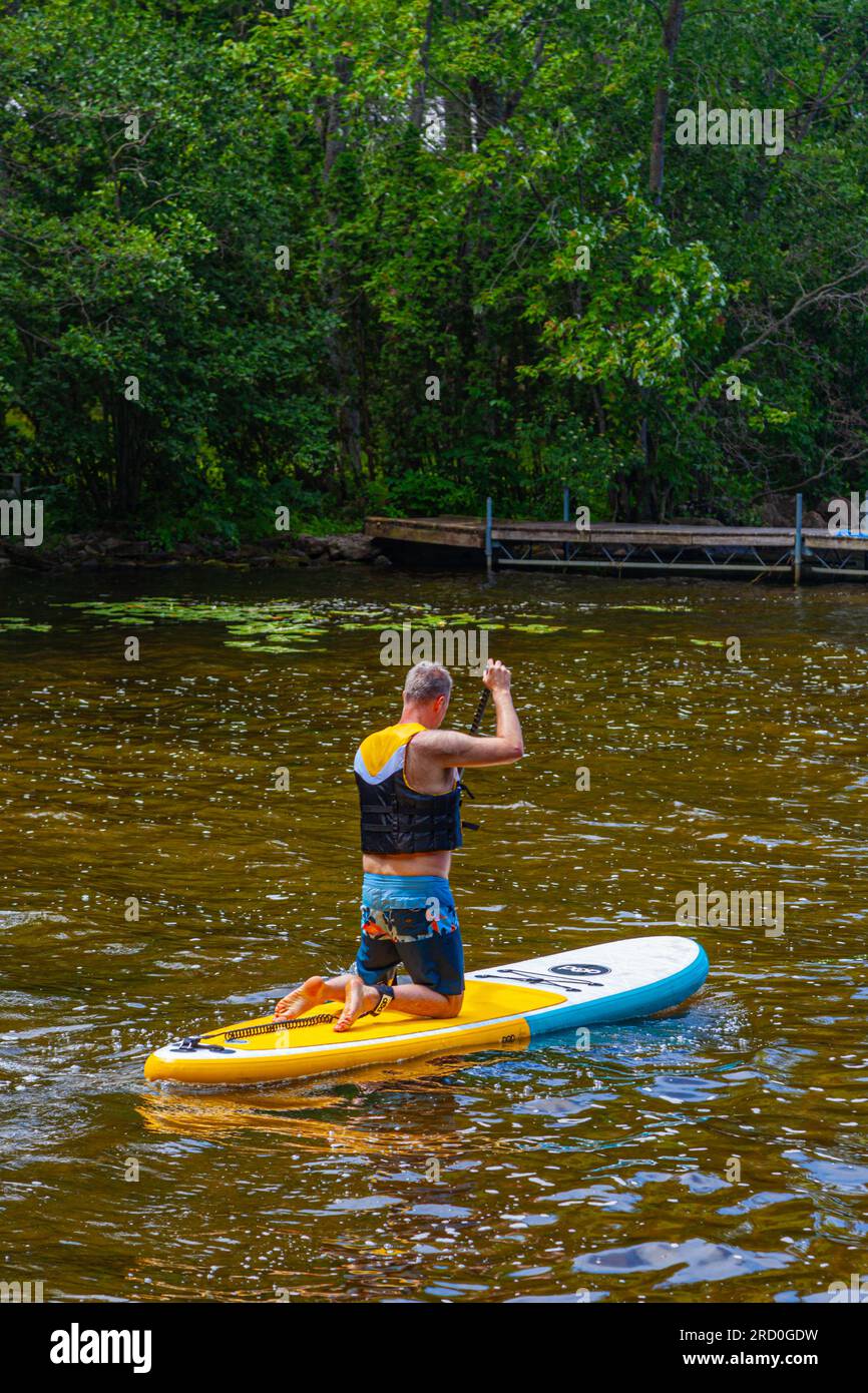 Sie verlassen das Ufer des Sparrow Lake auf einem Paddleboard in Muskoka Ontario Canada Stockfoto