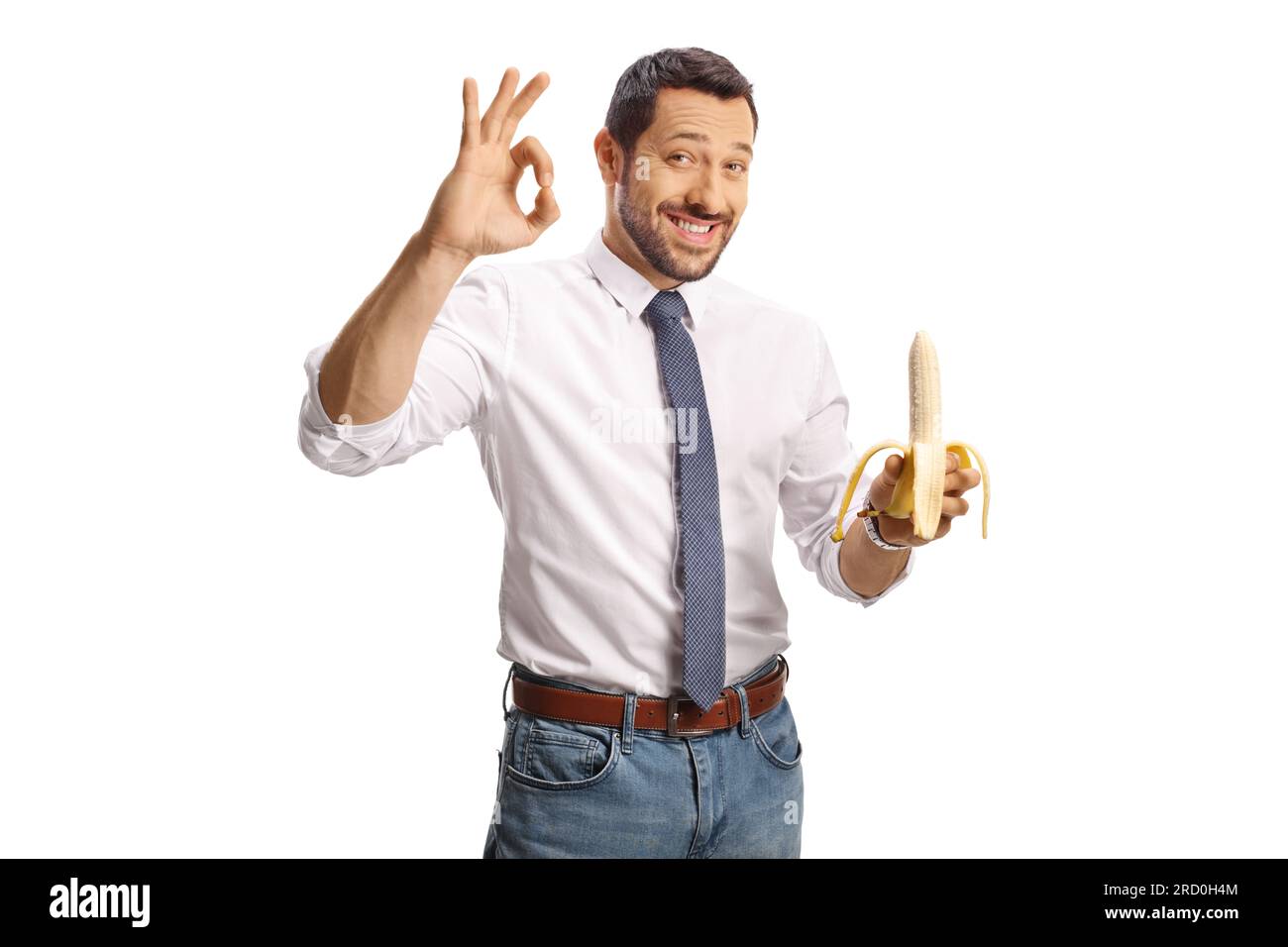 Glücklicher junger Mann, der eine Banane hält und ein gutes Zeichen auf weißem Hintergrund gezeichnet hat Stockfoto
