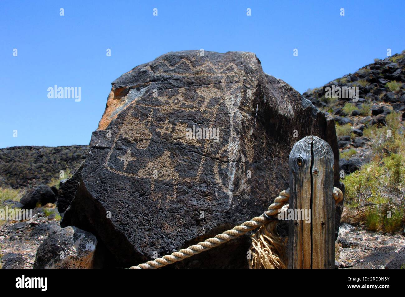 Großen Basaltfelsen hat Pueblo Indian petroglyph. Roped Weg führt durch eine der Trail Optionen im Petroglyph National Monument in Albuquerque Stockfoto