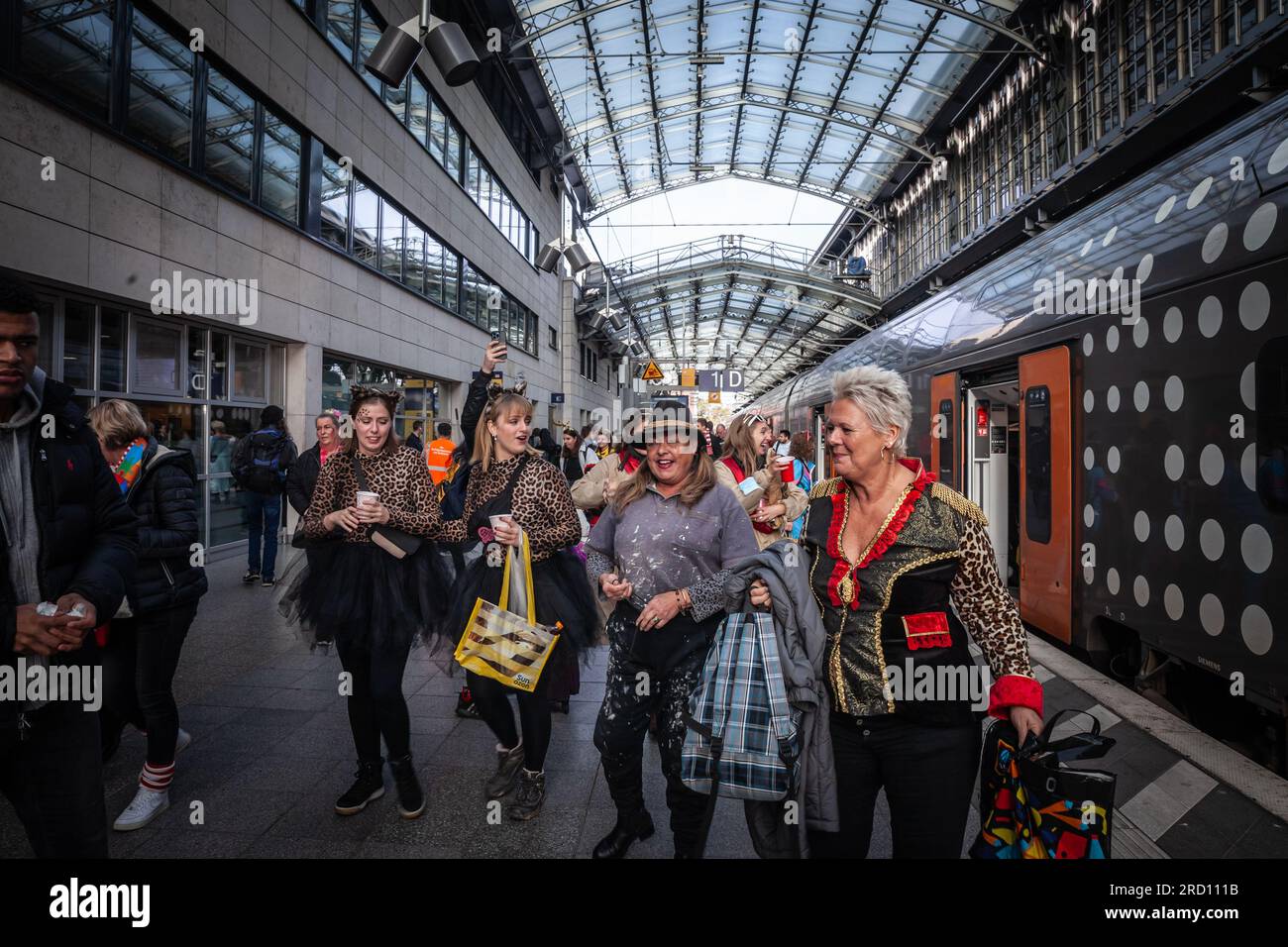 Bild von Personen in Kostümen für den Kölner Karneval, die auf der Plattform des Kölner Hbf stehen. Der Kölner Karneval ist Stockfoto