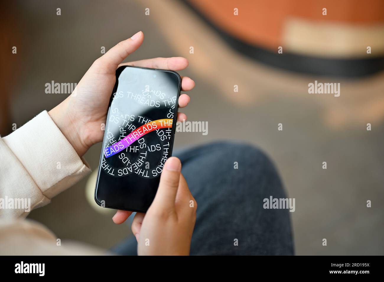 Chiang Mai, Thailand - Juli 17 2023: Eine asiatische Frau, die die Thread-Anwendung auf ihrem iPhone14 verwendet, während sie sich in einem Café entspannt. Stockfoto