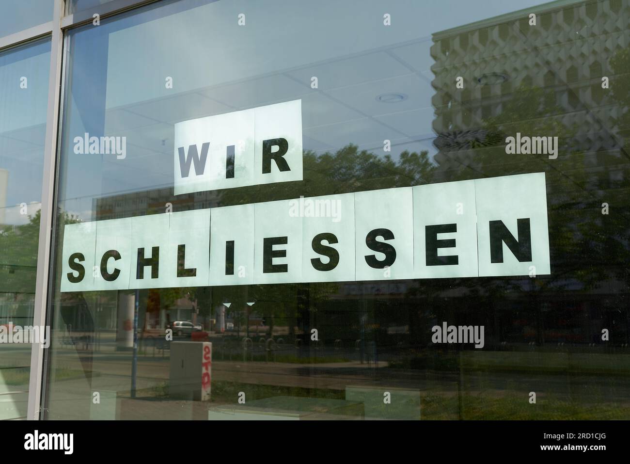 Unterschreiben Sie mit der deutschen Inschrift wir schliessen am Fenster eines Ladens in Magdeburg. Übersetzung: Wir schließen Stockfoto