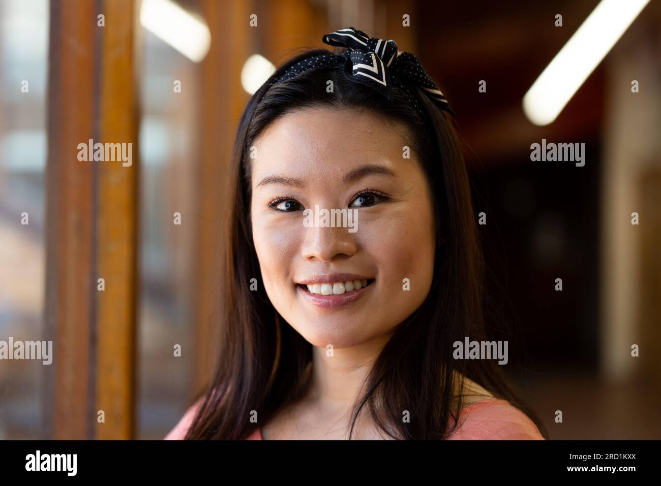 Porträt einer glücklichen asiatischen Lehrerin mit Band auf dem Schulkorridor Stockfoto