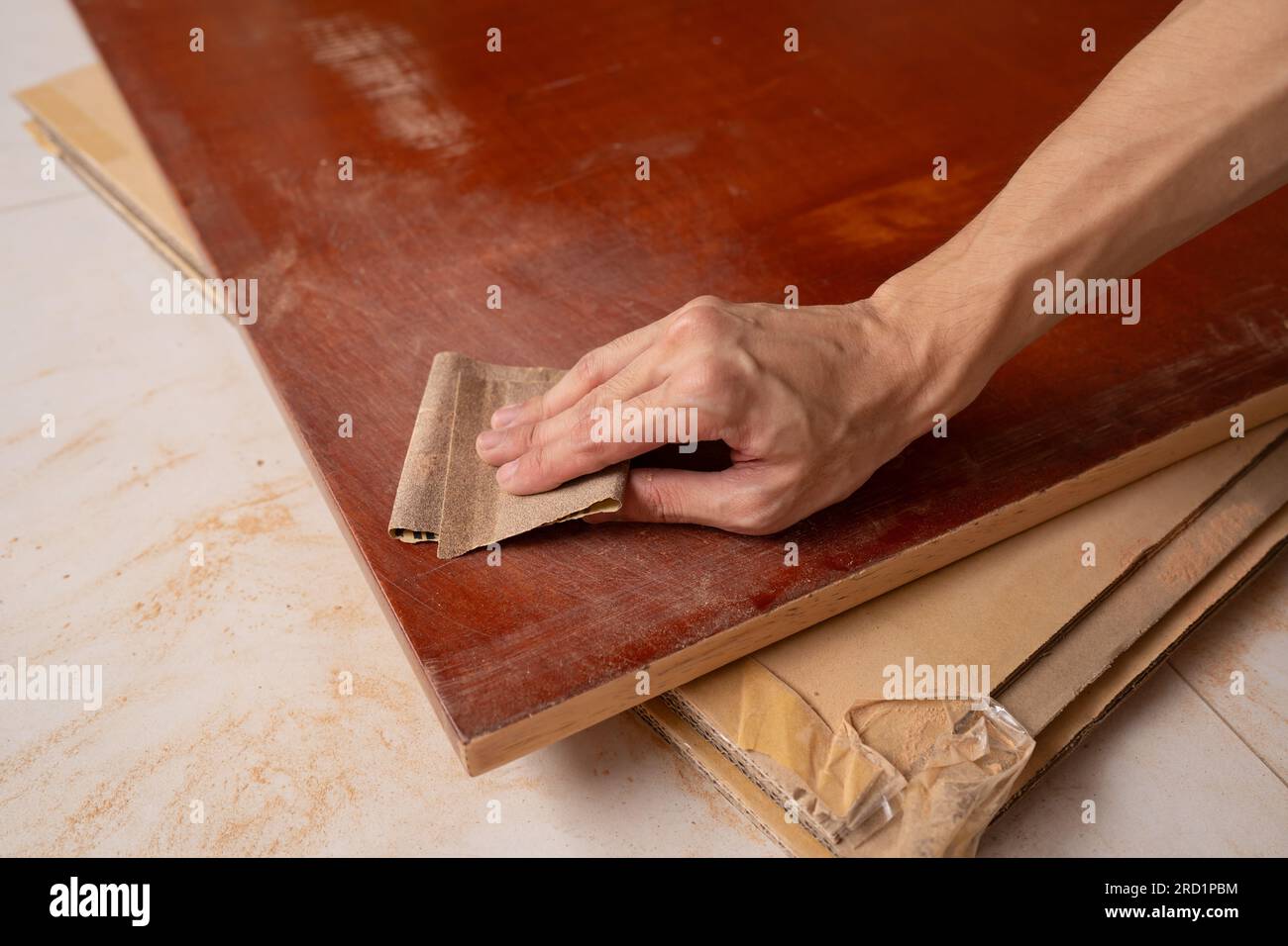 Entfernen Sie die Farbe vom Holztisch mit Schleifpapier Stockfoto