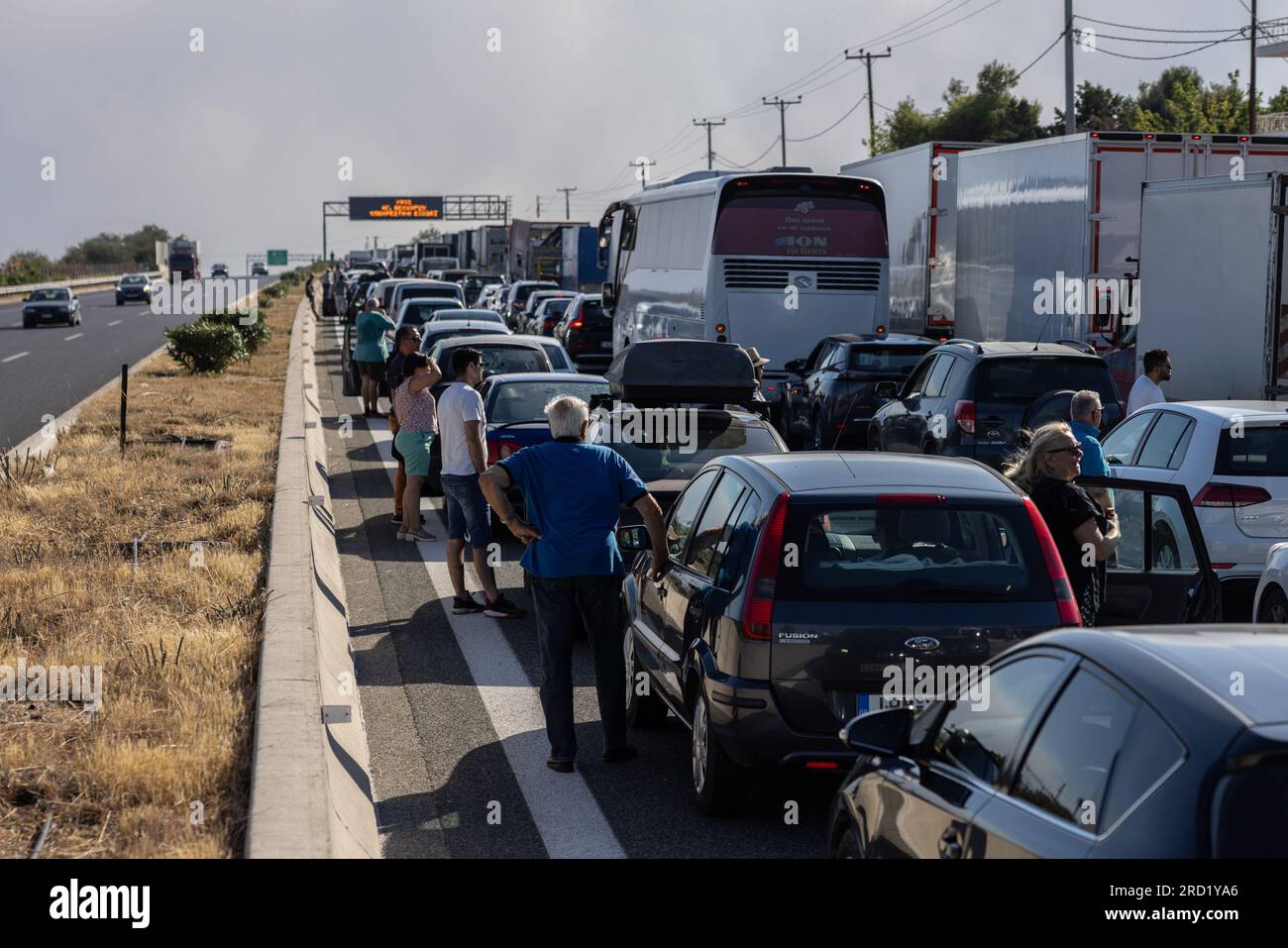 (230718) -- LOUTRAKI, 18. Juli 2023 (Xinhua) -- Fahrzeuge stehen aufgrund des Staus aufgrund von Waldbränden in der Nähe von Loutraki, Griechenland, auf einer Straße. Griechische Feuerwehrleute bekämpften am Montag in der Nähe von Kouvaras, einer Siedlung etwa 30 km südöstlich von Athen, sowie in der Nähe des Badeorts Loutraki, etwa 80 km südwestlich der Hauptstadt, und an zwei weiteren Orten Wildfeuer. (Foto: Lefteris Partsalis/Xinhua) Stockfoto