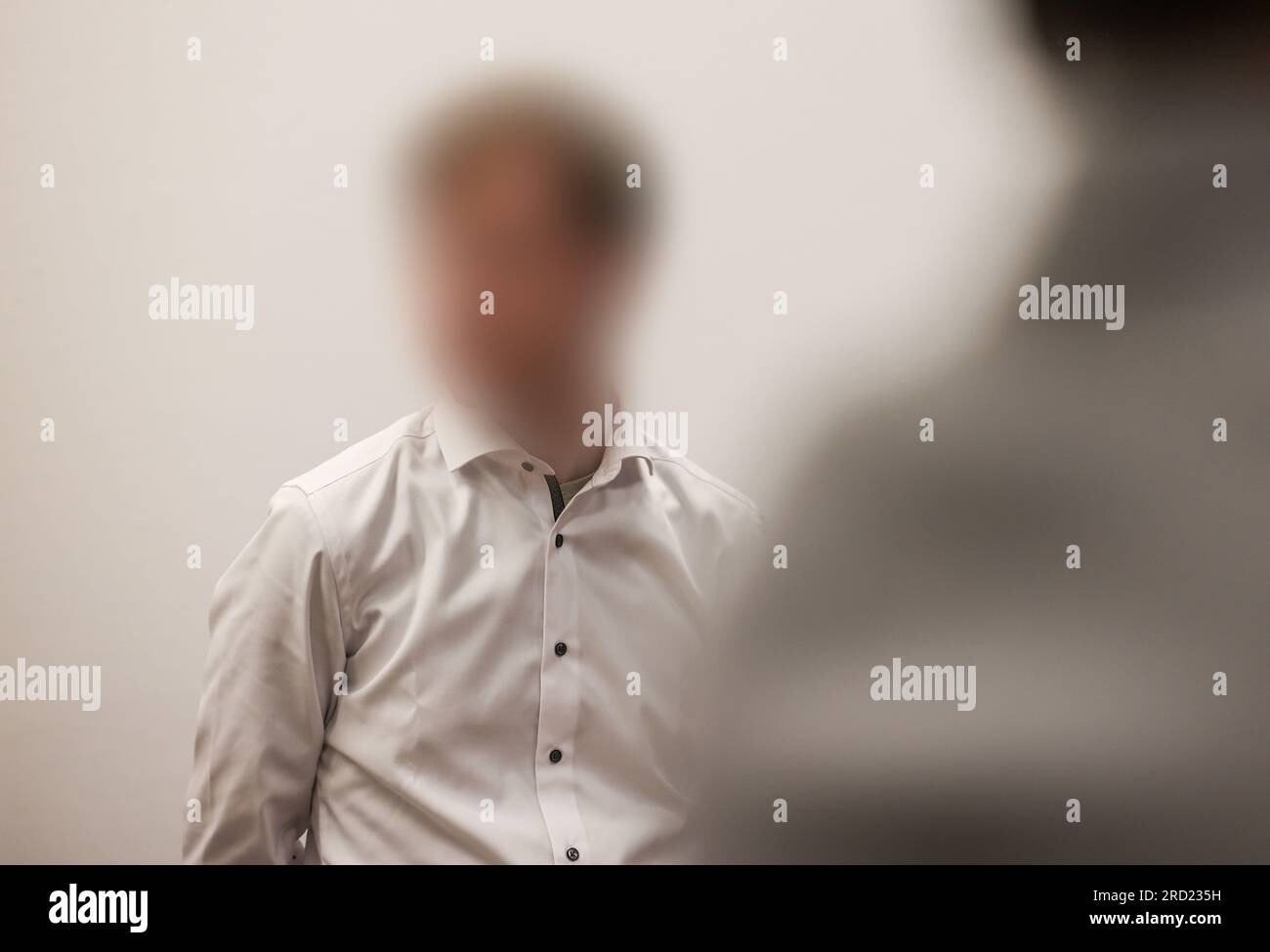 Köln, Deutschland. 18. Juli 2023. Der Angeklagte steht im Gerichtssaal. Der 22-Jährige hat angeblich das Haus seines Großvaters in Gummersbach angezündet, um ihn zu töten. Der Mann starb an Rauchvergiftung. Kredit: Oliver Berg/dpa - ACHTUNG: Beklagter auf Anordnung des Gerichts/dpa/Alamy Live News verpixelt Stockfoto