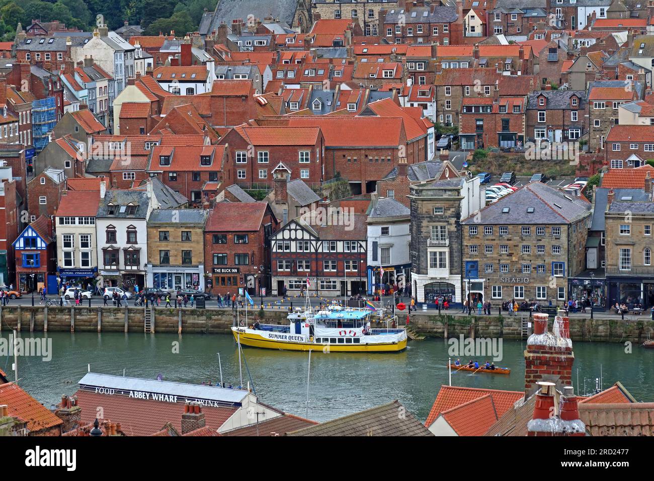 Blick auf West Cliff, Whitby Town, Hafen und Anlegestellen, einschließlich eines gelben Fischerboots, North Yorkshire, England, Großbritannien, YO21 3PU Stockfoto