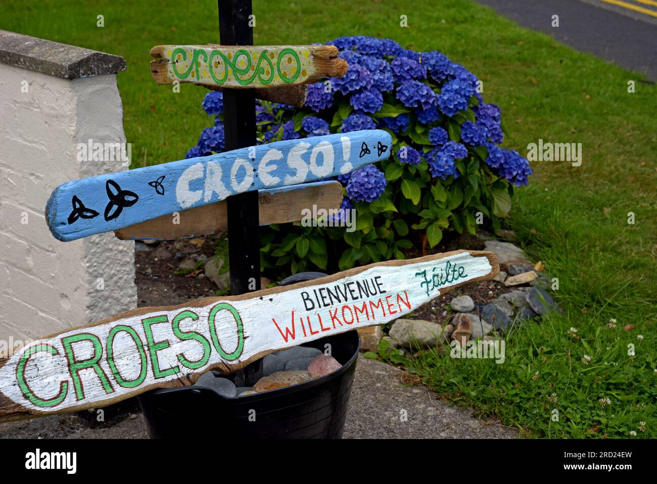 Begrüßungsschilder mit der Aufschrift „Welcome“ (Croeso) in Walisisch und anderen Sprachen, Criccieth, Gwynedd, Wales, Juli 2023 Stockfoto