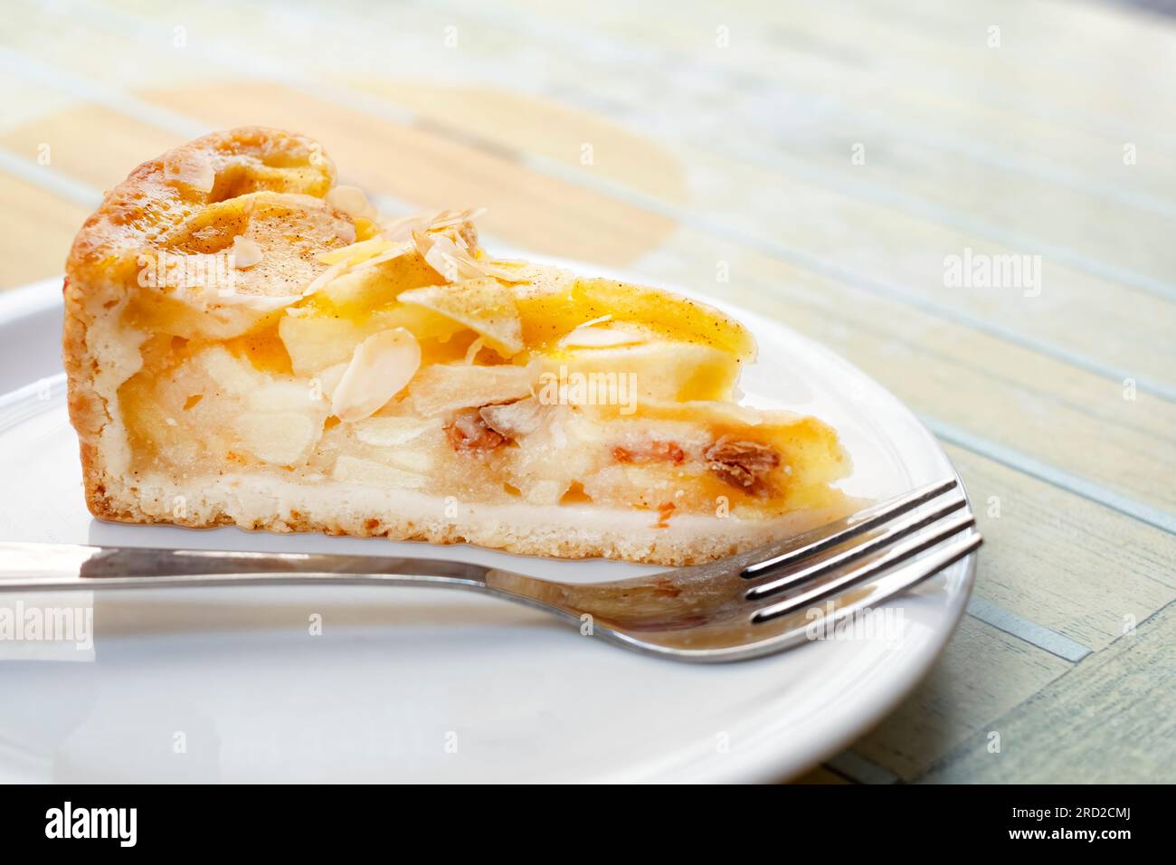 Ein Stück frisch zubereiteter Apfelkuchen. Der tiefe Kuchen hat eine Teigkruste und ist gefüllt mit großen Apfelscheiben Stockfoto