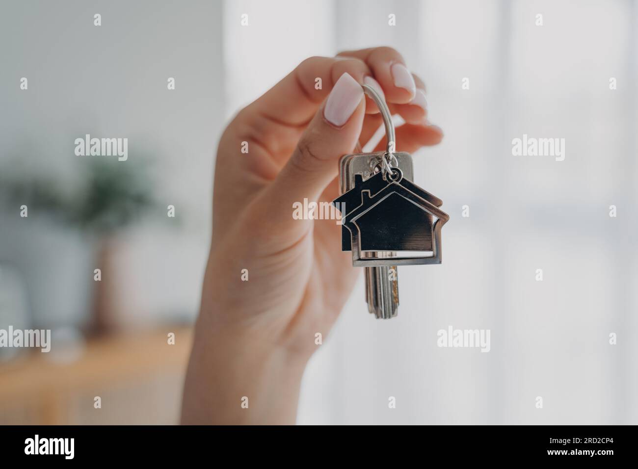 Schlüssel zum neuen Haus. Nahaufnahme einer weiblichen Hand mit einem Haufen Schlüssel. immobilienmaklerin macht Angebot und zeigt Schlüssel aus der neuen Wohnung. Kaufa Stockfoto