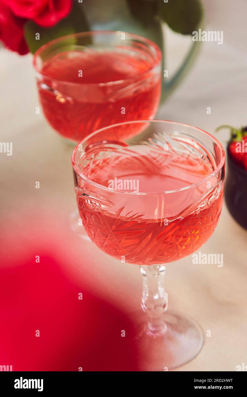 Glas hausgemachter Rotwein, Erdbeerwein, Infusionen. Romantischer, kostbarer Moment, genießen Sie das kleine Momente Konzept. Stockfoto