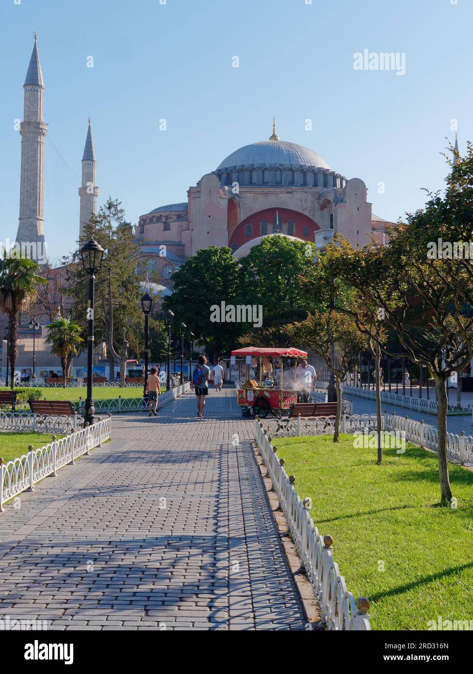 Gärten des Sultanahmet Parks mit der Hagia Sophia Moschee. Der rote Verkaufswagen verkauft gerösteten Mais. Istanbul, Türkei Stockfoto