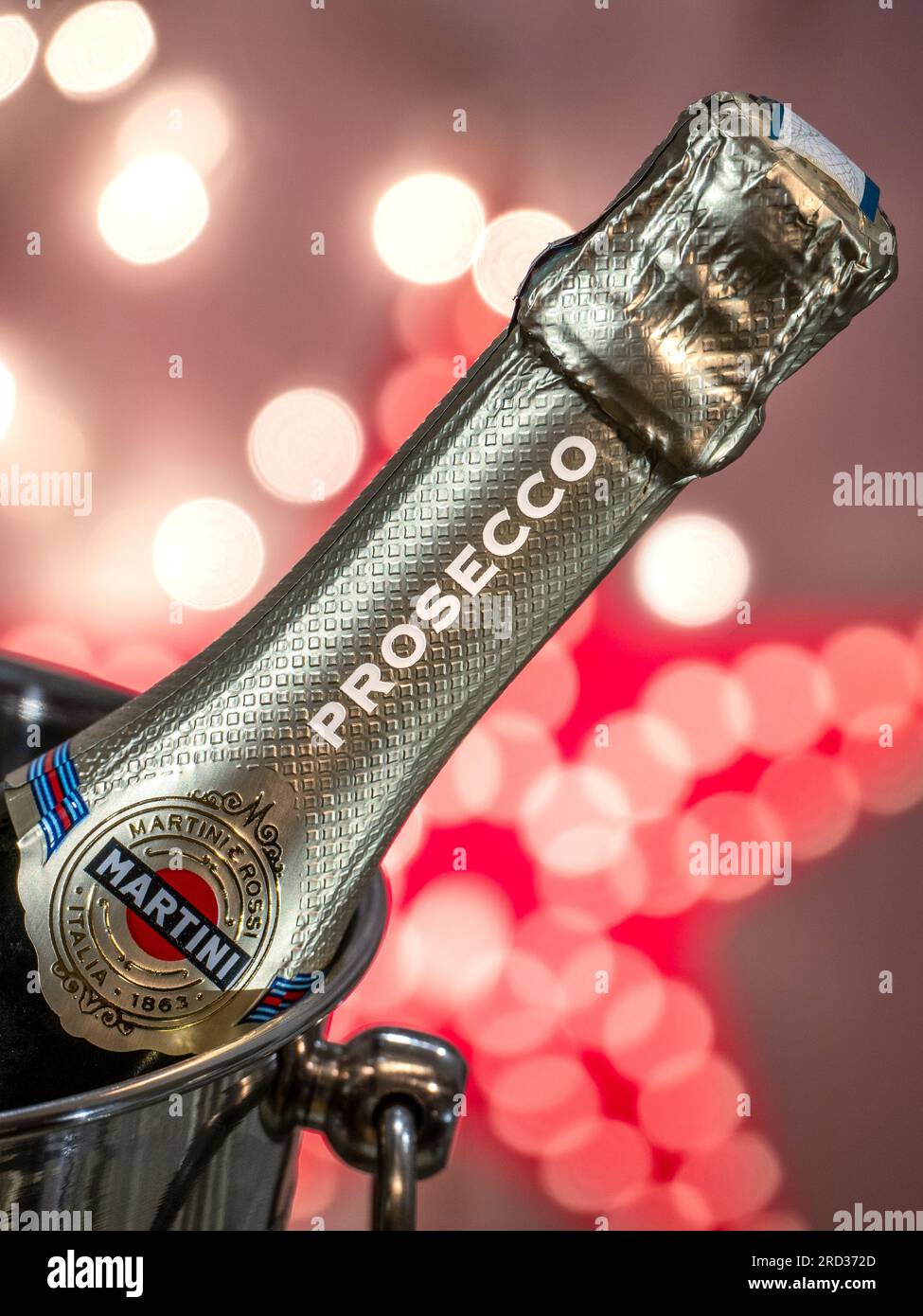 PROSECCO WEIHNACHTSBELEUCHTUNG Prosecco Flasche auf Eis in Weinkühler mit Partystern und glitzernden Lichtern Stockfoto