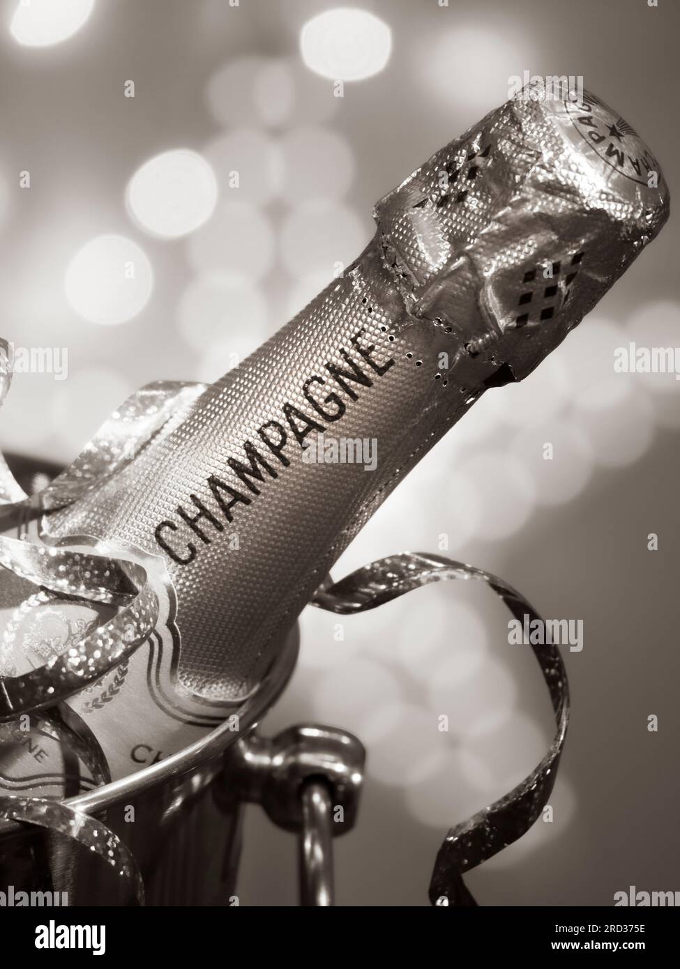 CHAMPAGNERFLASCHE RETRO EPOCHE B&W PARTY LICHTER auf Eis in Wein Kühlbox Champagner Eiskübel, Partystreuer und glitzernde Lichter zur Feier Stockfoto
