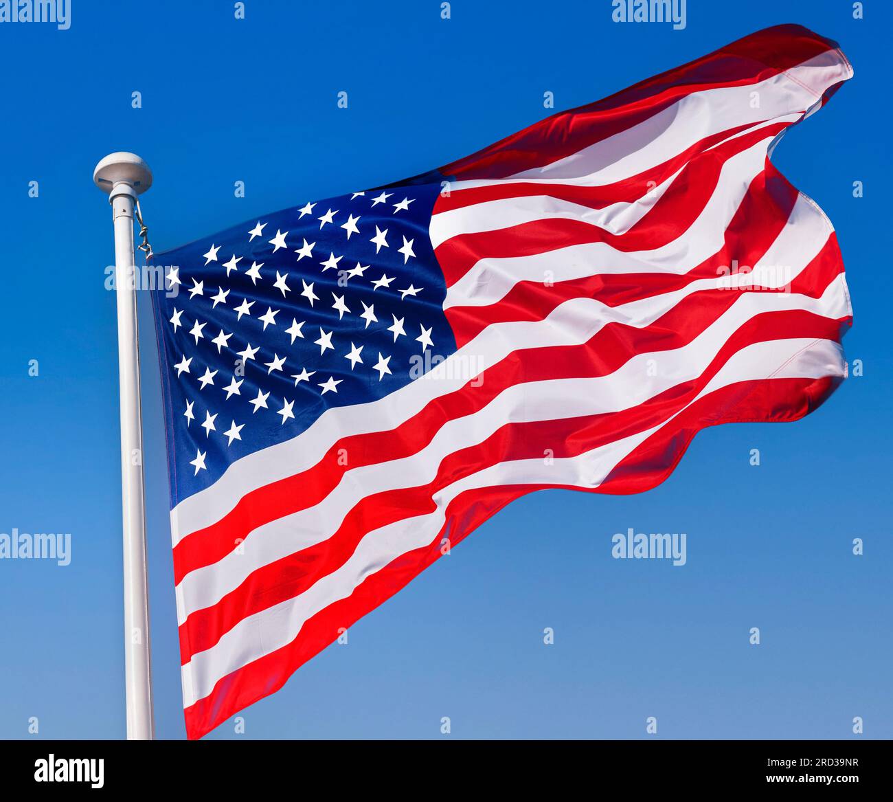 Stars & Stripes American Flag in Aktion und hält aus nächster Nähe an, strömt in einer Brise mit sonnigem blauen Himmel hinter den USA Stockfoto