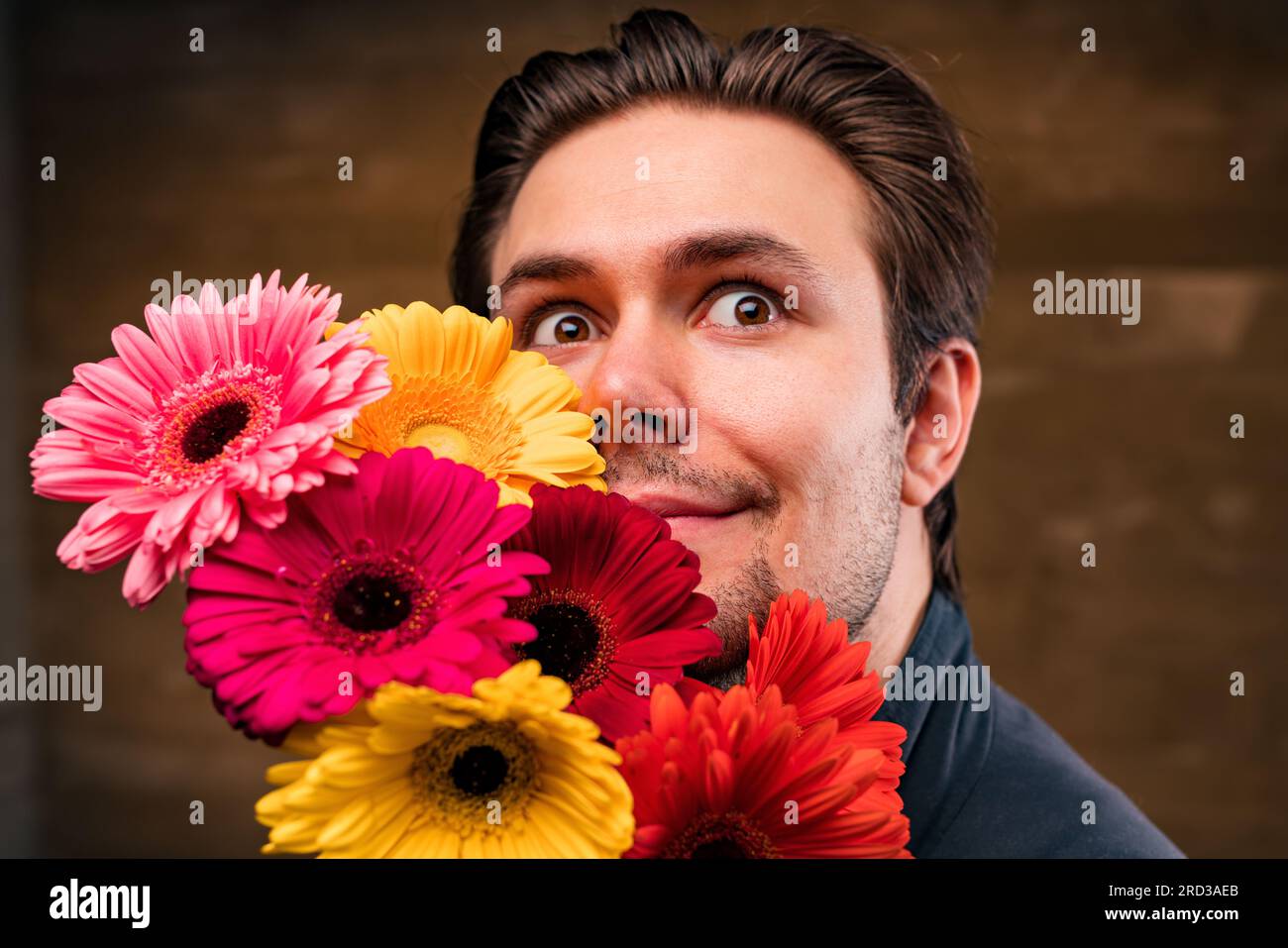 Junger, gutaussehender Mann mit Blumenporträt Stockfoto
