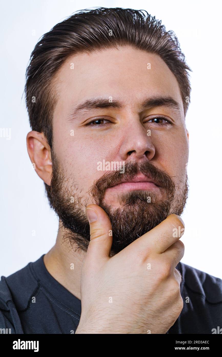 Junger, nachdenklicher Mann mit Bartporträt auf weißem Hintergrund Stockfoto