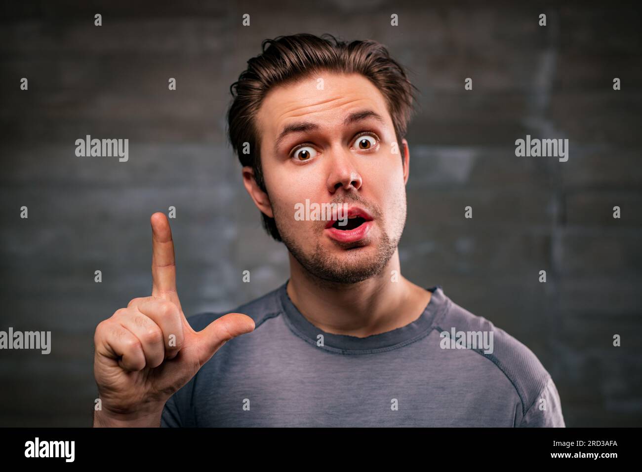 Junger, gutaussehender Mann mit Ideenporträt auf grauem Hintergrund Stockfoto