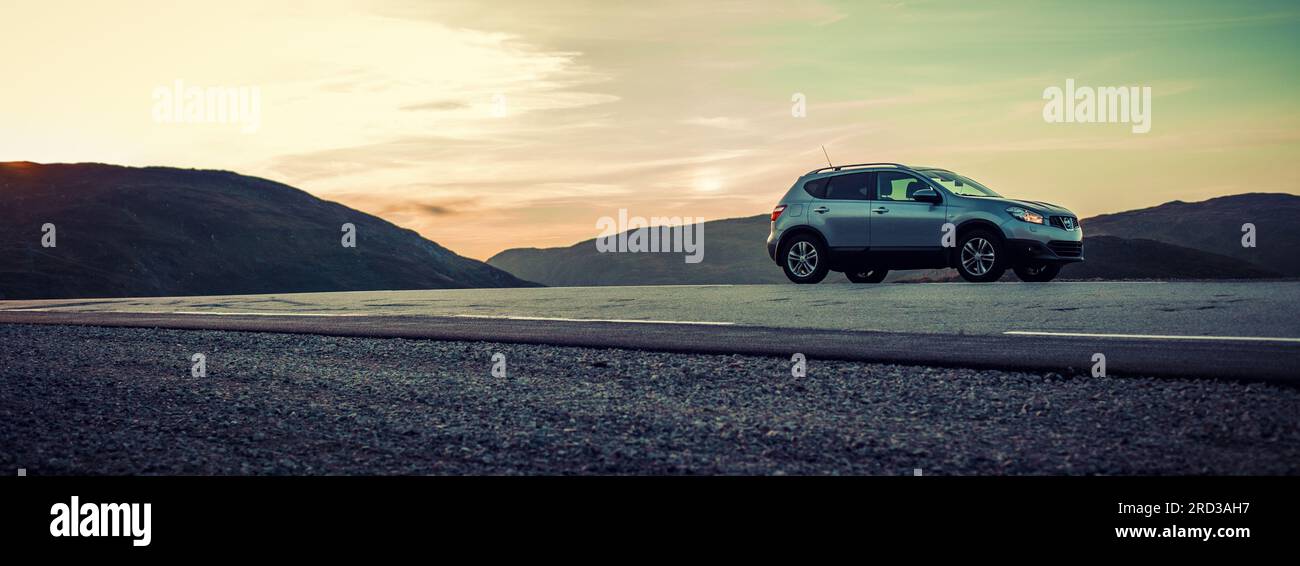 Das Auto parkt am Straßenrand in einem Hochgebirgspanorama Stockfoto