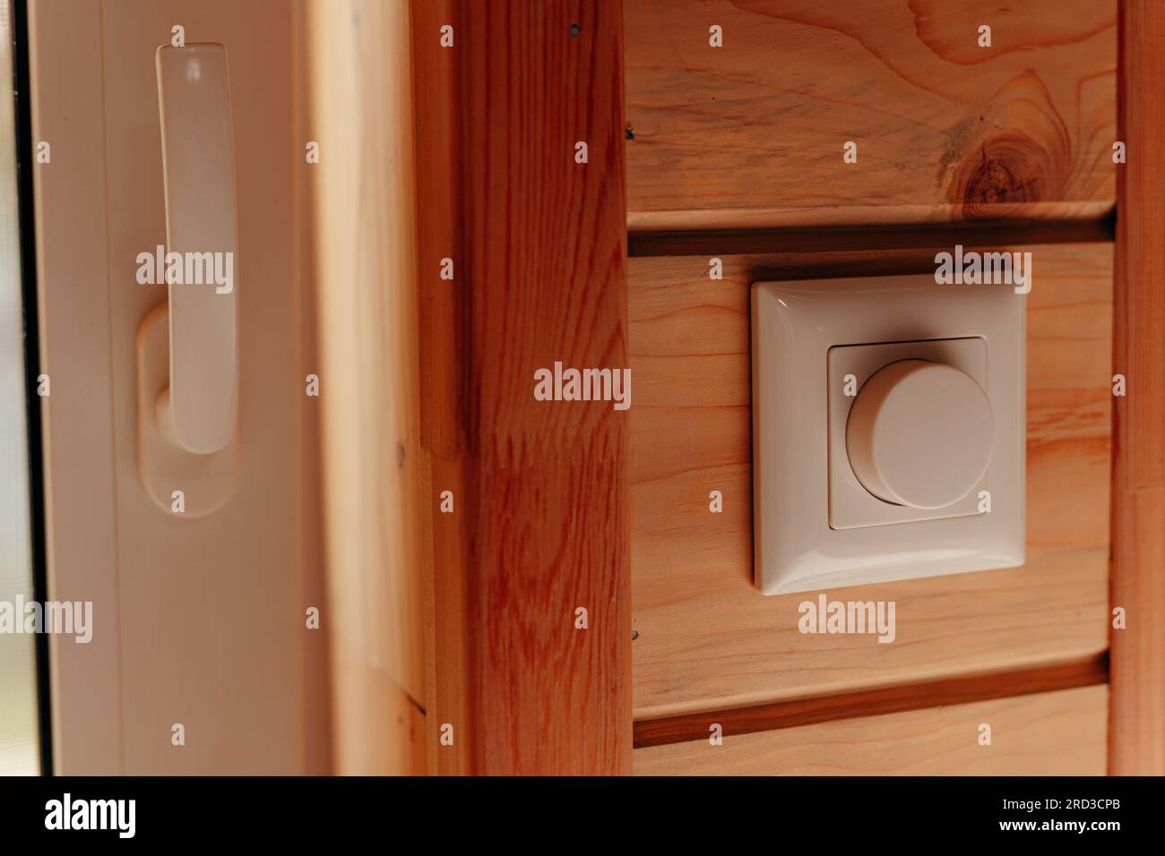Nahaufnahme elektrischer Dimmer-Schalter für einstellbare Helligkeitsregelung im Holzhaus Stockfoto