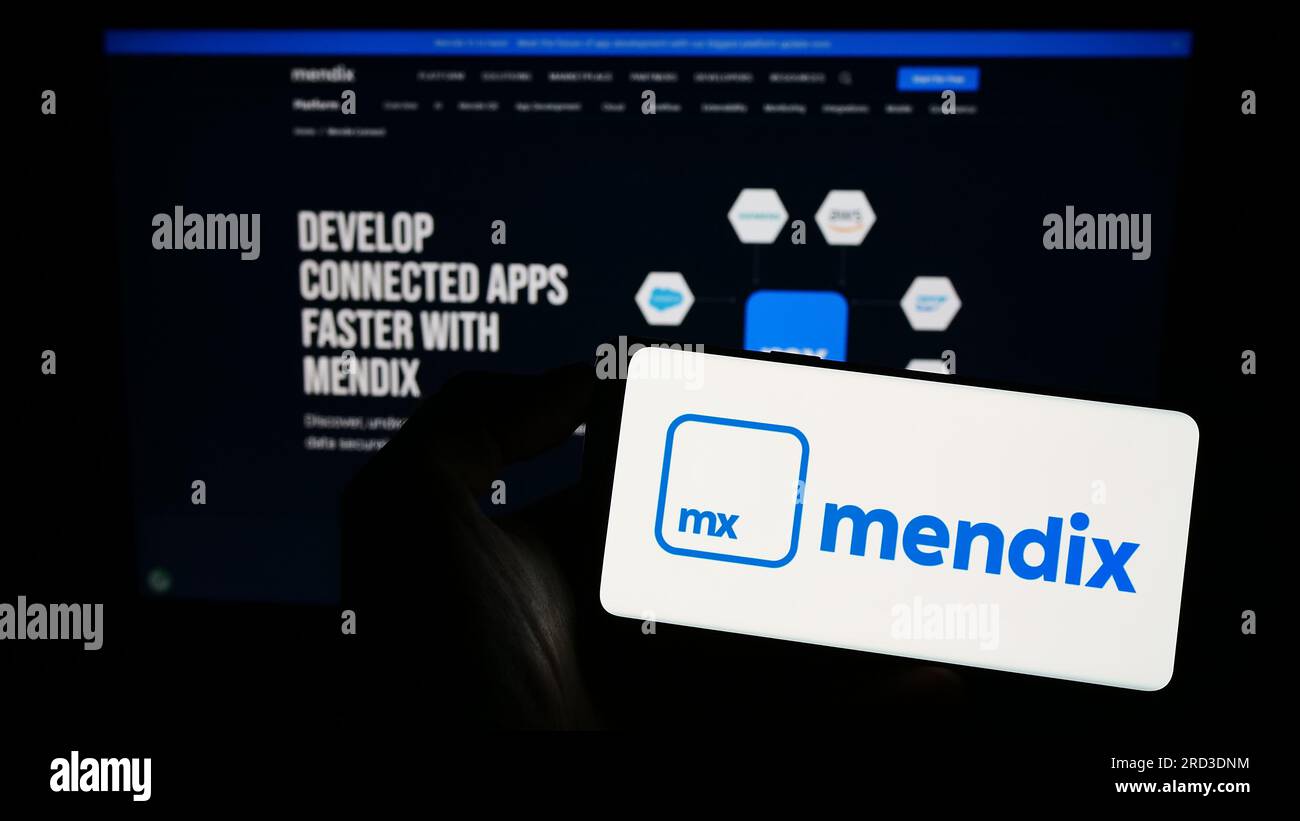 Person, die ein Mobiltelefon mit dem Logo des Softwareunternehmens Medix Technology B.V. auf dem Bildschirm vor der Unternehmenswebseite hält. Konzentrieren Sie sich auf das Display des Telefons. Stockfoto