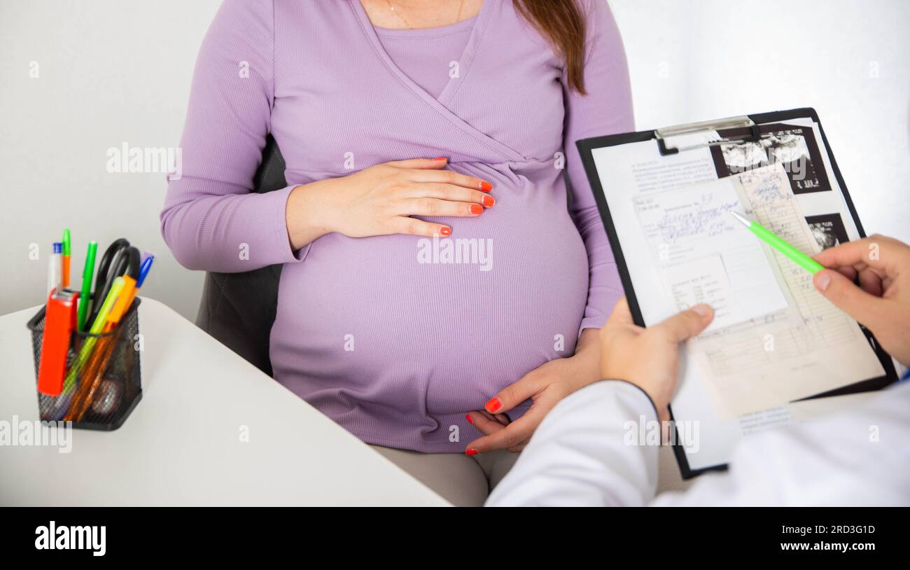 Schwangeres Mädchen in der Arztpraxis. Ergebnisse von Blutuntersuchungen bei einem schwangeren Mädchen. Abnahme von Hämoglobin und Blutzucker während der Schwangerschaft, im Stockfoto