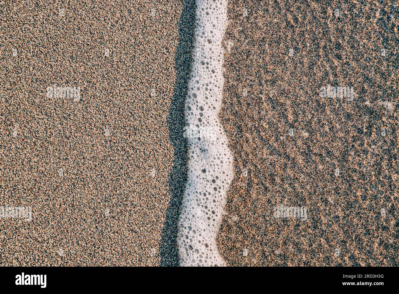 Hintergrundstruktur des Sandstrands, die die natürliche Schönheit und die einzigartigen Muster in den Sandkörnern einfängt. Stockfoto