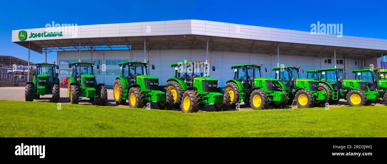 Kiew, Ukraine - 24. August 2020: Die leistungsstarken Traktoren im John Deer-Geschäft in Kiew, Ukraine, am 16. Juni 2020. Reihe brandneuer John Deere-Traktoren vor dem Laden des örtlichen Konsortiums, Ausstellung der neuesten landwirtschaftlichen Maschinen. Stockfoto