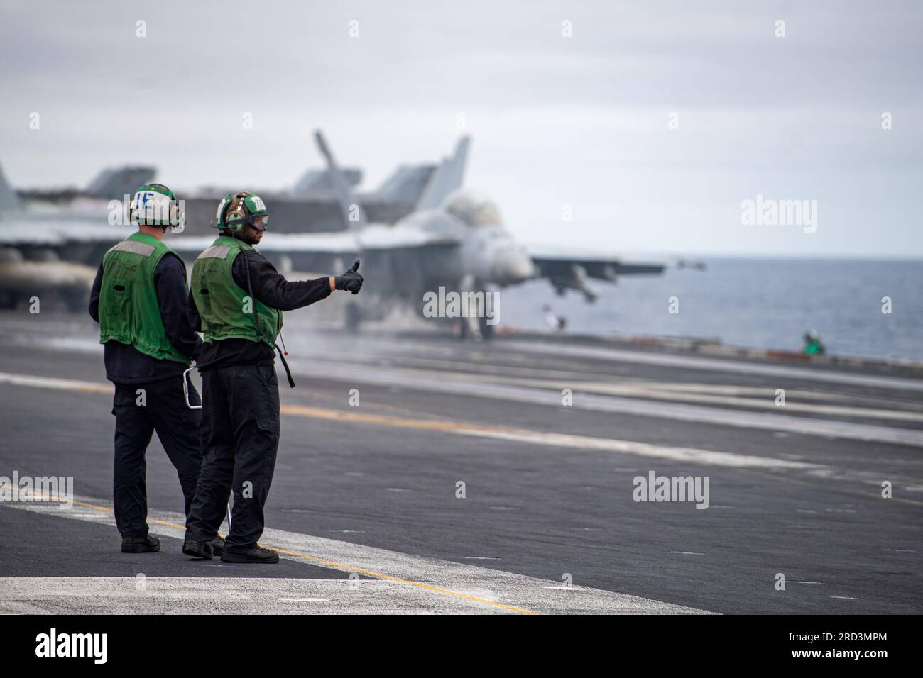 230627-N-KU796-1172 PAZIFIK (27. JUNI 2023) USA Marinesachverständige beobachten, wie eine F/A-18F Super Hornet von den ‚Fighting Redcocks‘ der Streikkkämpfer-Staffel (VFA) 22 sich auf den Start vom Cockpit des Flugzeugträgers USS Nimitz (CVN 68) vorbereitet. Nimitz führt gerade Routineoperationen durch. Stockfoto