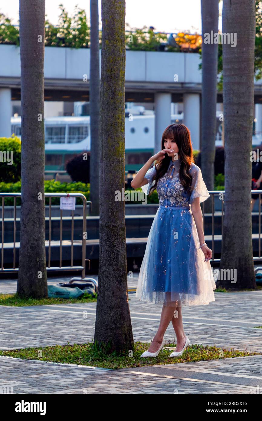Junge attraktive chinesische Models, die neben Bäumen posieren, in Hongkong, SAR, China Stockfoto