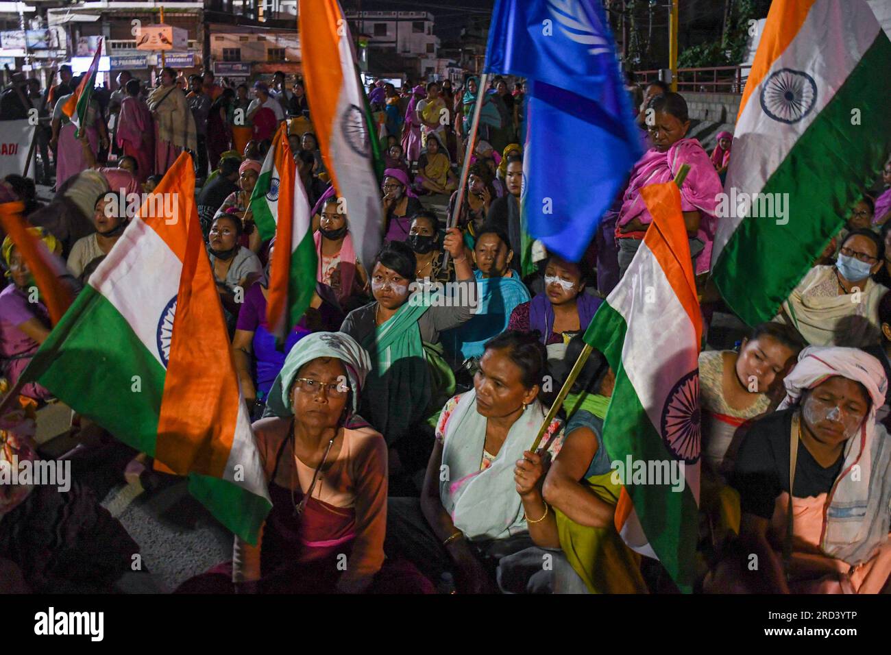 Demonstranten der Frauenaktivistengruppe Meira Paibi halten indische Flaggen, während sie während einer Sit-in-Demonstration in Imphal eine Straße blockieren. Die Meira Paibis sind Meitei-Frauen, die aus allen Teilen der Gesellschaft im Imphal-Tal kommen, weithin respektiert werden, eine starke moralische Kraft haben. „Meira“ bedeutet „Licht“ und „Paibi“ bedeutet „Frau“. Diese Frauen sind Teil einer einzigartigen Bewegung namens „Meira Paibi“, die in Manipur entsteht. Und sie haben gegen verschiedene Probleme wie soziale Ungerechtigkeiten, Menschenrechtsverletzungen, Gewalt und Diskriminierung protestiert. Stockfoto