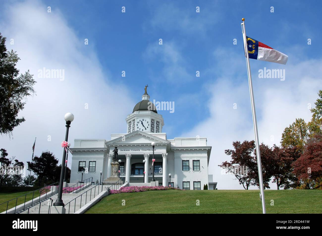 Das elegante Jackson County Courthouse liegt auf einem Hügel mit Blick auf Sylva, North Carolina. Die Flagge von North Carolina fliegt vor einem leuchtend blauen Himmel. Stockfoto