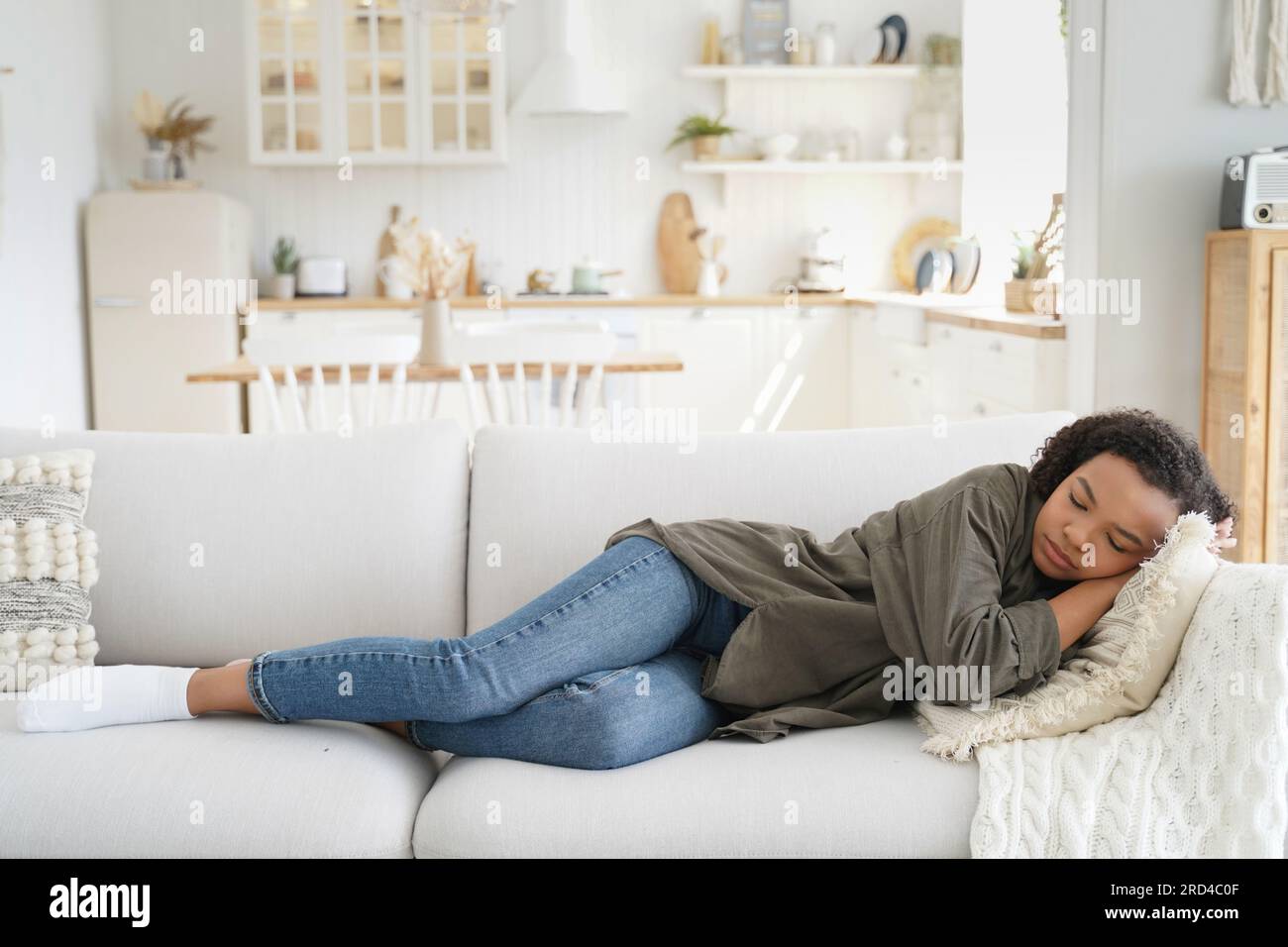 Erschöpfte afroamerikanische Mädchen Nickerchen auf dem Sofa zu Hause nach einem anstrengenden Tag. Stockfoto