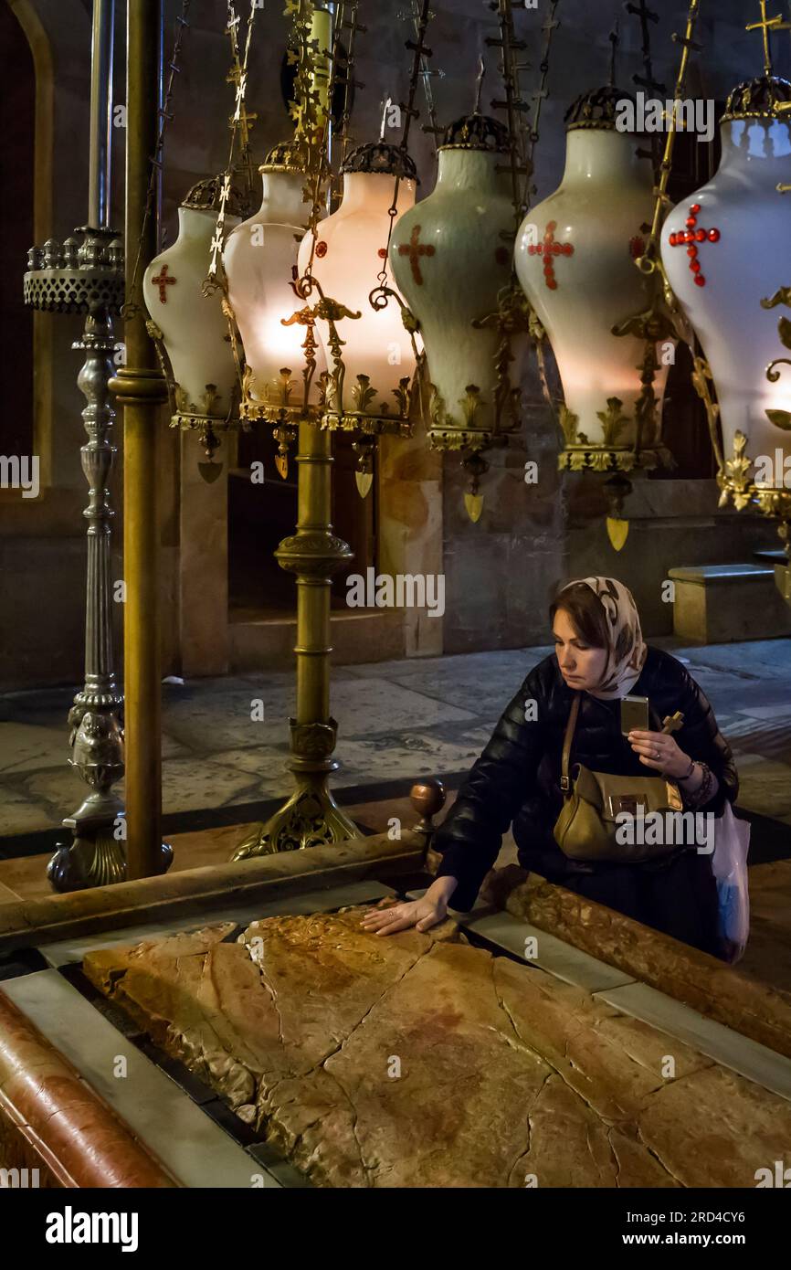 Frau, die den Stein der Salbung in der Grabeskirche im christlichen Viertel der Altstadt von Jerusalem tödlich berührt Stockfoto