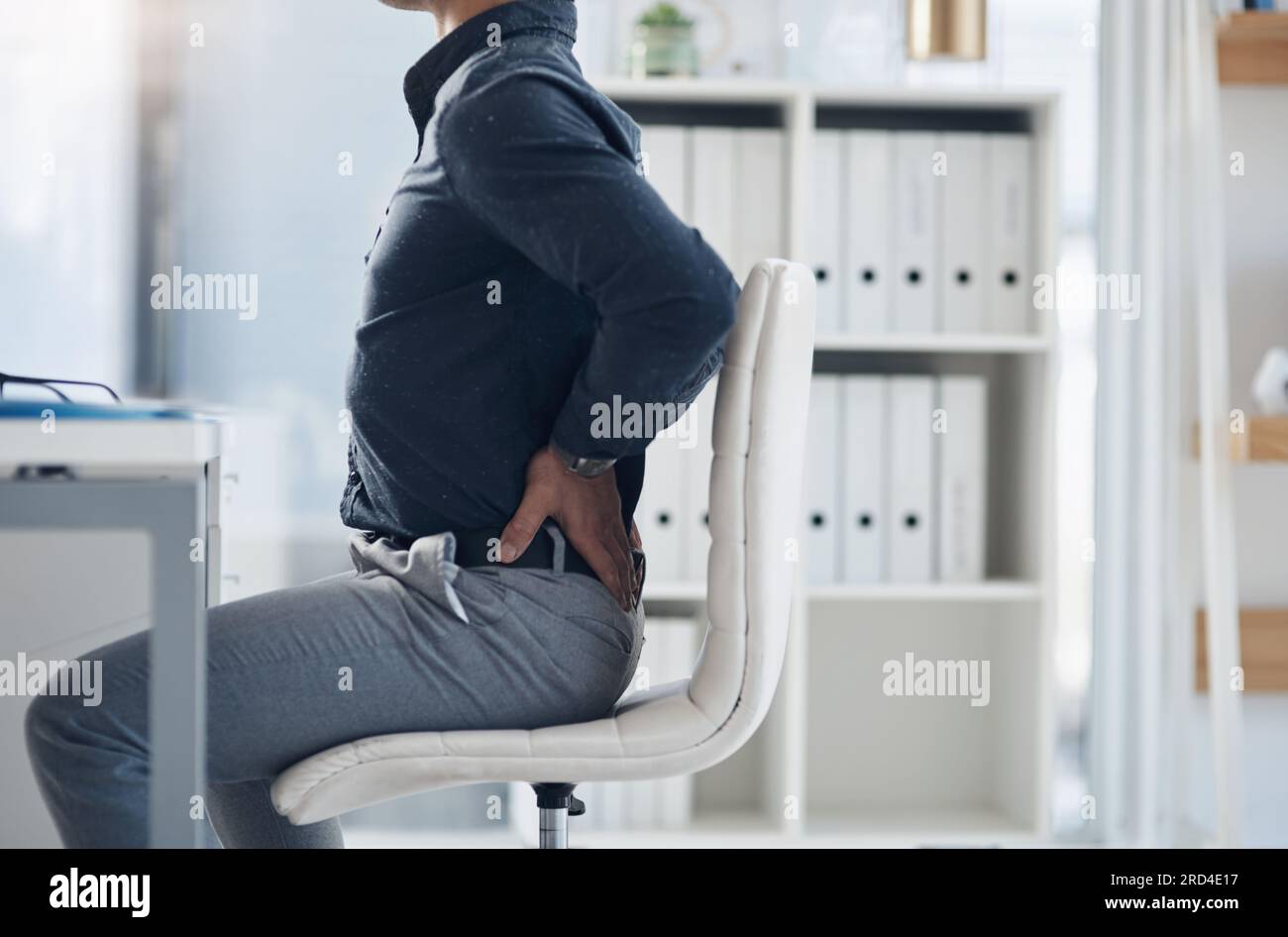 Müde, Rückenschmerzen und Schmerzen bei einem Geschäftsmann im Amt wegen Stress, Frustration und Muskelermüdung. Burnout, Spannung und Körper mit Nahaufnahme des Mannes Stockfoto