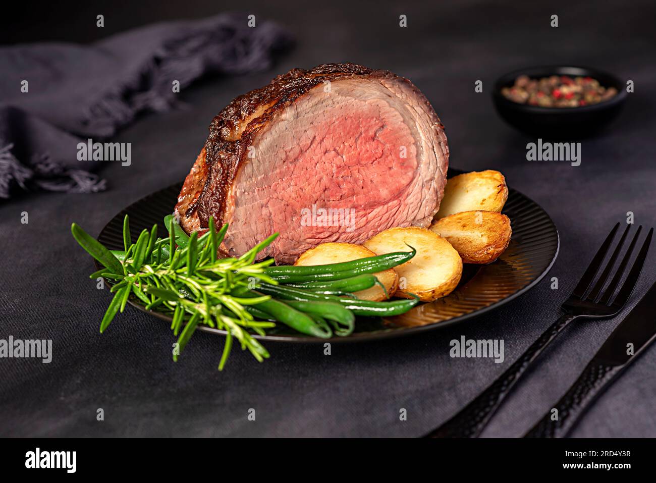 Lebensmittelfotografie von gebratenem Rinderbrust, Filet; gebraten, Kartoffeln, Bohnen, Rosmarin, Pfeffer, Gewürze Stockfoto