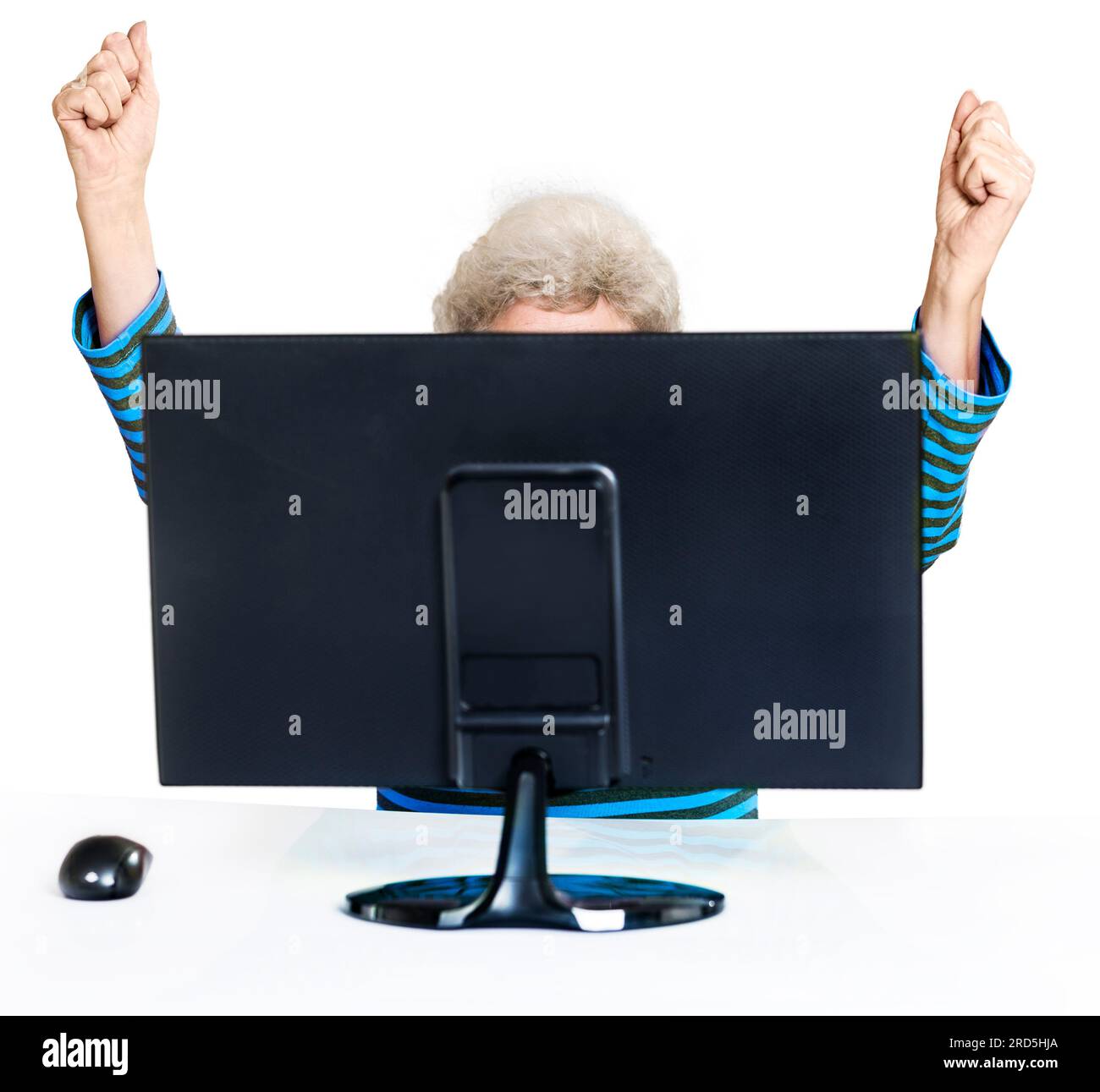 Eine Geste des Erfolgs, des Sieges. Senior versteckt hinter einem Computermonitor. Fröhlich mit erhobenen Händen. Weißer Hintergrund Stockfoto