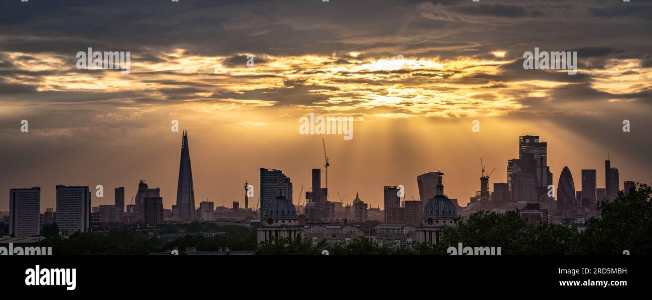 London, Großbritannien. 18. Juli 2023 UK Weather: Dramatische Sonnenuntergänge über der Stadt, die von der Spitze des Greenwich Park aus gesehen werden, beenden einen weiteren warmen Sommertag (mehrere Bilder, Panorama-Verschmelzung). Kredit: Guy Corbishley/Alamy Live News Stockfoto