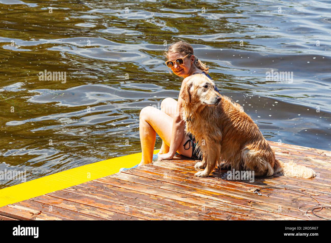 Eine Frau und ihr Hund sitzen auf einem Schwimmwagen im Sparrow Lake Muskoka Ontario Kanada Stockfoto