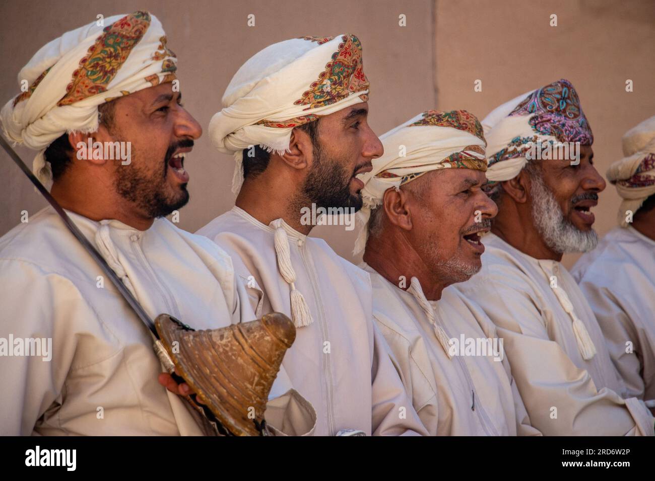 Eine Gruppe omanischer Männer in traditioneller Kleidung führt einen Tanz in Nizwa, Oman, auf Stockfoto