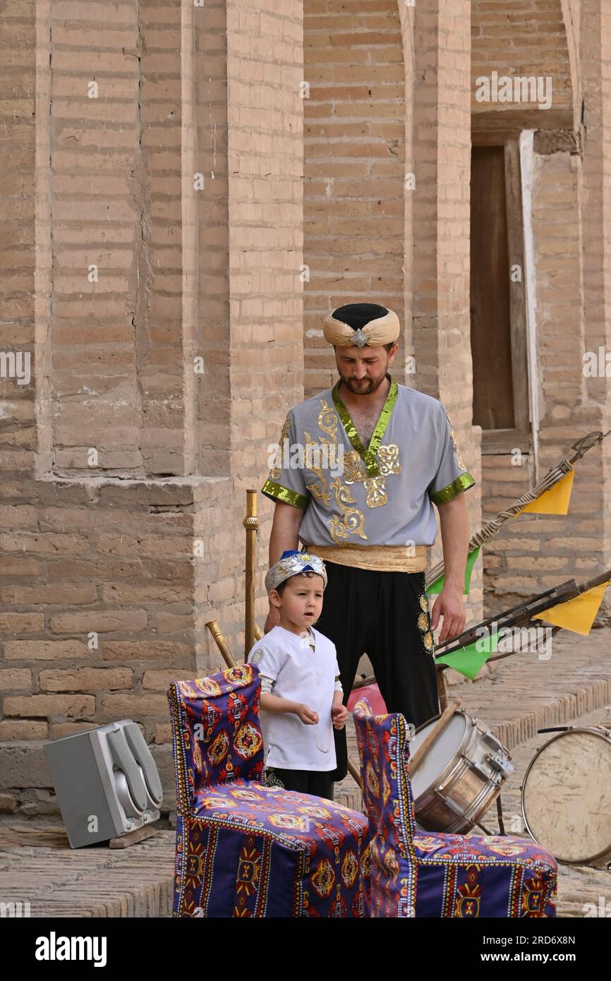 Usbekischer akrobat mit seinem Sohn vor einer Vorstellung in einer Madrasa in Khiva, Usbekistan Stockfoto