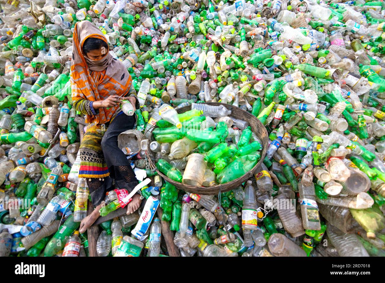 Dhaka, Bangladesch. 19. Juli 2023, Dhaka, Dhaka, Bangladesch: Arbeiter sortieren gebrauchte Plastikflaschen in einer Recyclingfabrik in Dhaka, Bangladesch. Die Mitarbeiter tragen dazu bei, zu verhindern, dass die Flaschen entsorgt, auf Deponien entsorgt, wo es 1.000 Jahre dauern kann, bis sie biologisch abgebaut sind, oder verbrannt werden, wodurch giftige Dämpfe entstehen. Da die Hauptstadt von Bangladesch, Dhaka, eine der am dichtesten besiedelten Regionen der Welt ist und fast 19 Millionen Menschen beheimatet, ist der jährliche Plastikverbrauch von Dhaka pro Kopf mehr als dreimal so hoch wie der nationale Durchschnitt für städtische Gebiete und liegt bei 22,25 kg. Kredit: ZUMA Press, Inc./Alamy Live News Stockfoto