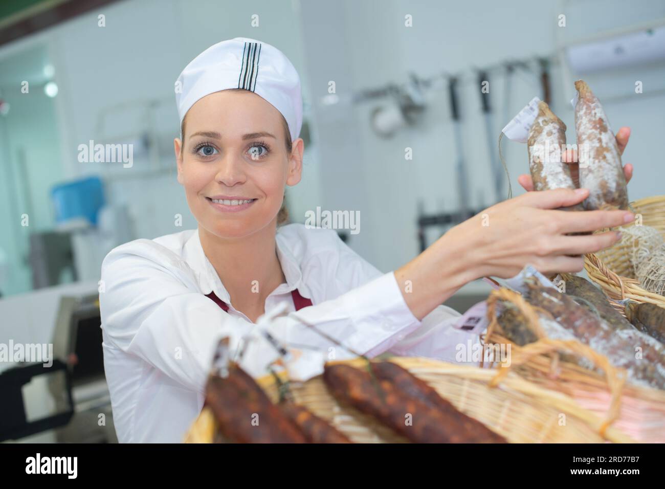 Fröhliche europäische Metzgerin in der Fleischhandlung Stockfoto